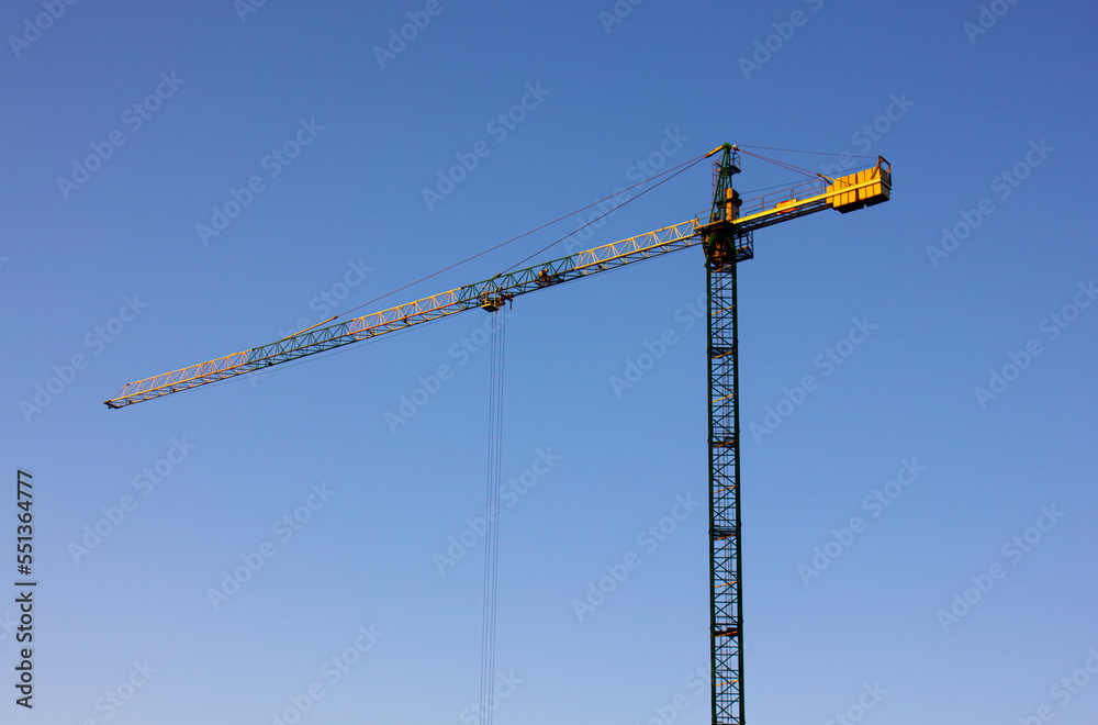 Crane over blue sky background. The process of cunstructing.