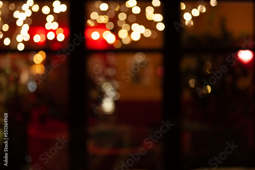 blurred image of a restaurant festively decorated with golden lights at night - celebration background for Christmas, New Year, Holiday, party, dinner, invitation