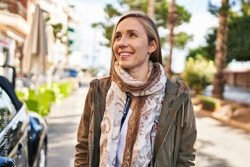 Young blonde woman smiling confident looking to the side at street