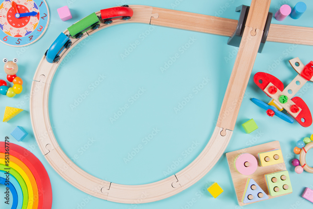 Baby kids toys frame background. Wooden railway with train and colorful