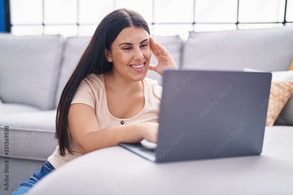 Young beautiful hispanic woman using laptop sitting on floor at home Young beautiful hispanic woman using laptop sitting on floor at home