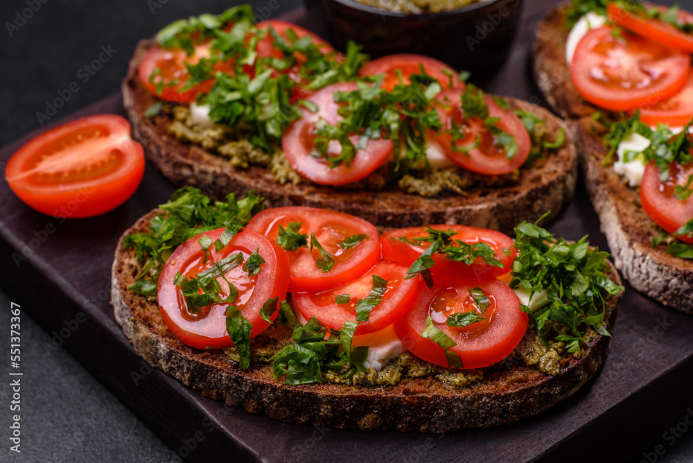 Tasty bruschetta with tomatoes, mozzarella, basil, spices and herbs Tasty bruschetta with tomatoes, mozzarella, basil, spices and herbs