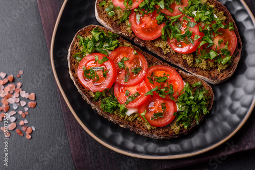 Tasty bruschetta with tomatoes, mozzarella, basil, spices and herbs