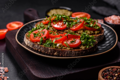 Tasty bruschetta with tomatoes, mozzarella, basil, spices and herbs