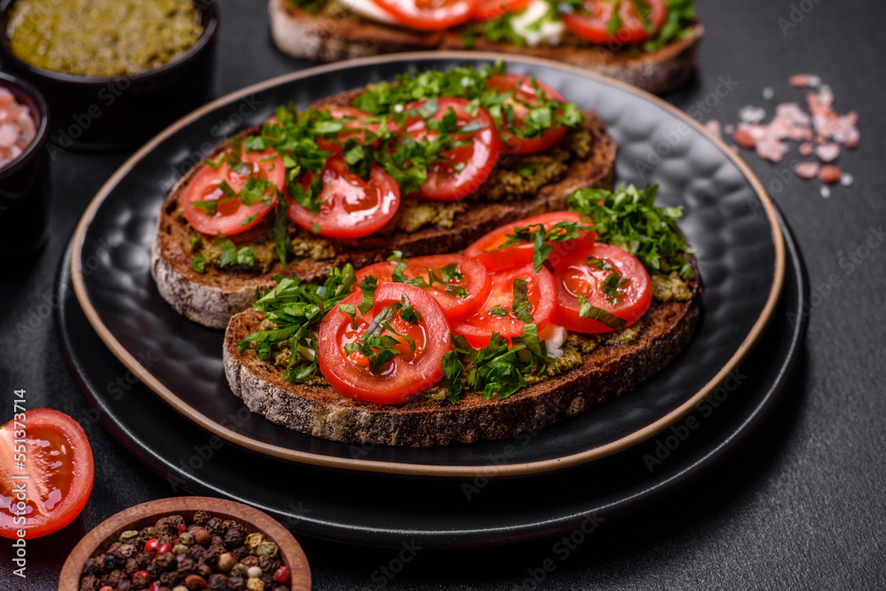 Tasty bruschetta with tomatoes, mozzarella, basil, spices and herbs