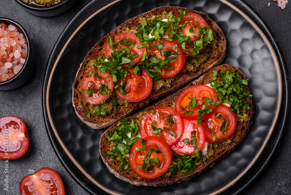 Tasty bruschetta with tomatoes, mozzarella, basil, spices and herbs Tasty bruschetta with tomatoes, mozzarella, basil, spices and herbs
