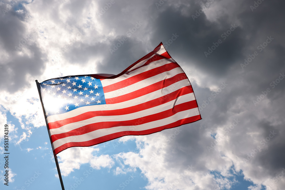 US American flag waving in stormy cloudy sky
