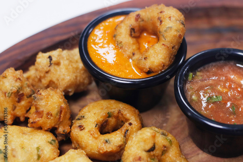 traditional indian snack food, crispy deep fried vada and chutneys in a serving plate © libin