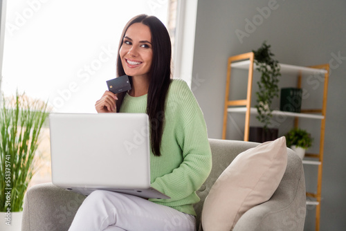 Photo of joyful pretty lady assistant banker rejoice get salary have savings want but new device netbook macbook sit indoors workspace