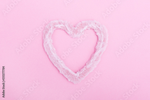 Fototapeta Naklejka Na Ścianę i Meble -  Frame of fluffy fur heart on a pink background. The concept of Valentine's day, love, dating and wedding. Minimalism, background, monochrome.