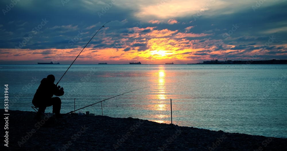 Fisherman catches fish, majestic sunset around