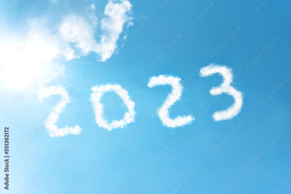 Numbers 2023 symbol inscription on a background of blue sky from white smoke of clouds lit by a bright sun. Numbers 2023 symbol inscription on a background of blue sky from white smoke of clouds lit by a bright sun.