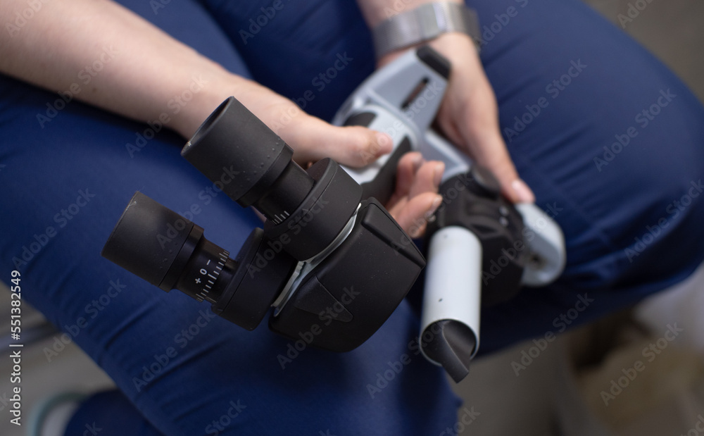 A veterinary ophthalmologist in uniform holds a portable slit lamp in