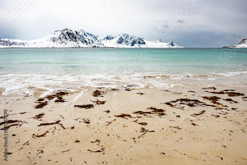 scenic landscape with beach, ocean and mountains near  Nusfjord town at the Lofoten Islands in  Norway photo