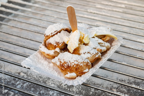 Dutch poffertjes with powdered sugar close-up. Cooking Dutch traditional street food small pancakes poffertjes at the winter and autumn market in the Netherlands. 