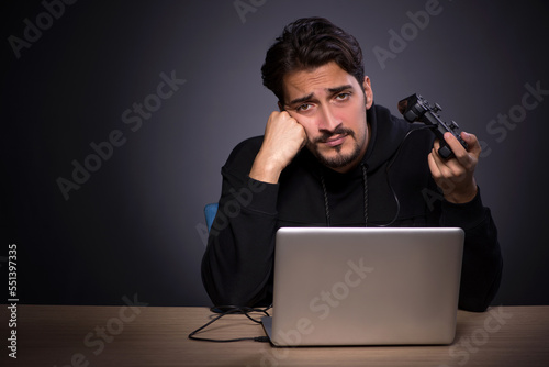 Young male gamer on grey background