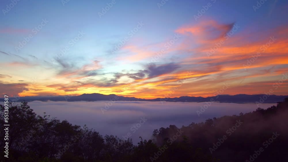 Amazing sky above the mountain rang..slow floating fog blowing cover on the top of mountain look like as a sea of mist. .beautiful sunrise in the mist background.. Amazing sky above the mountain rang..slow floating fog blowing cover on the top of mountain look like as a sea of mist. .beautiful sunrise in the mist background..