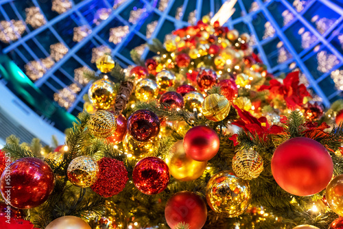 Christmas tree full of lights, garlands, colorful balls and decorations. Abstract christmas background. Bottom-up view of christmas tree. New Year mood.