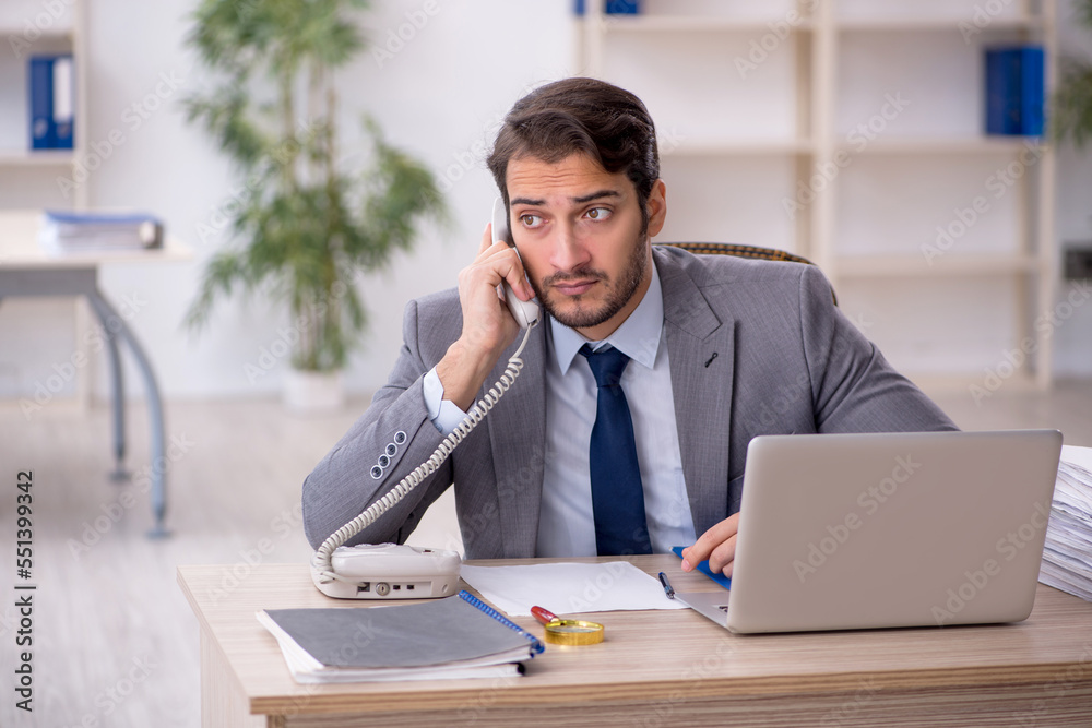 Young male employee and too much work in the office Young male employee and too much work in the office