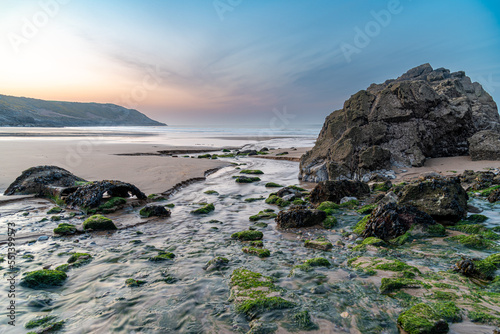 rocks on the beach in Wales during sunrise
 photo