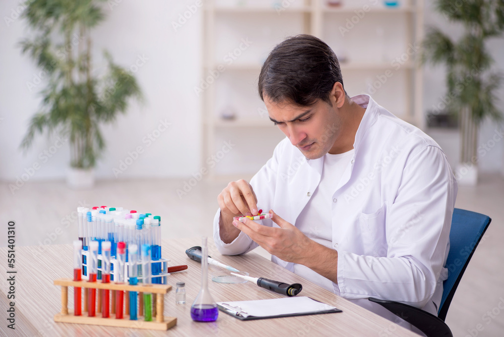 Young male chemist working at the lab Young male chemist working at the lab