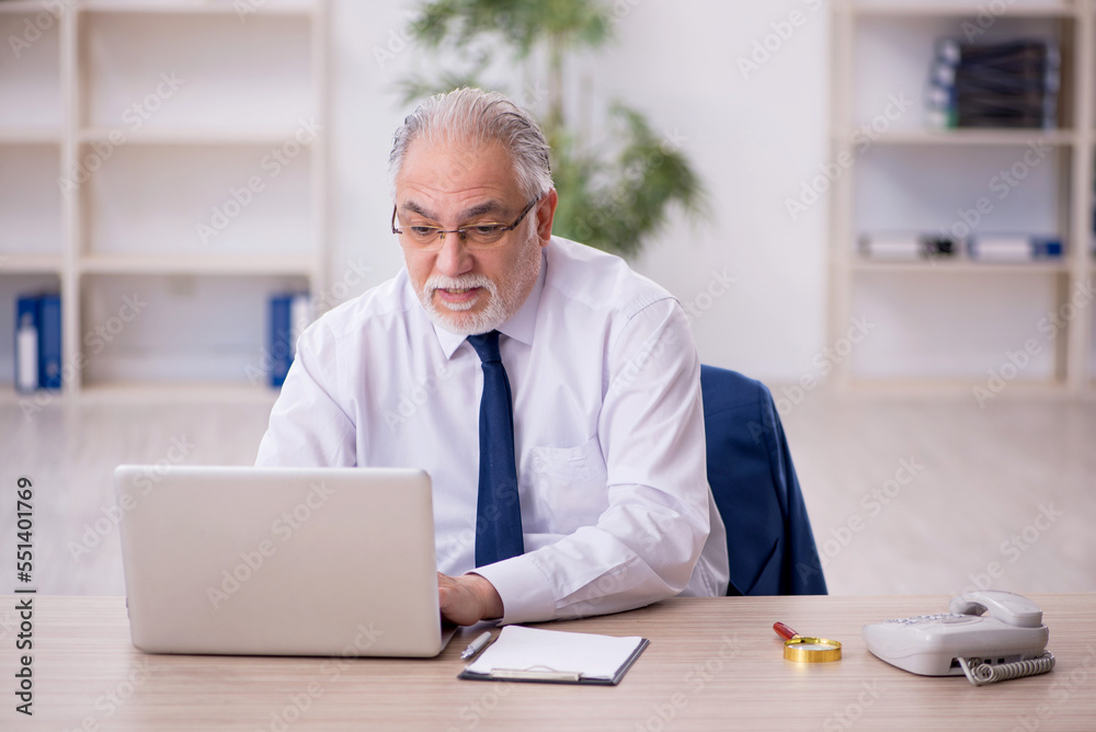 Old male boss working at workplace Old male boss working at workplace