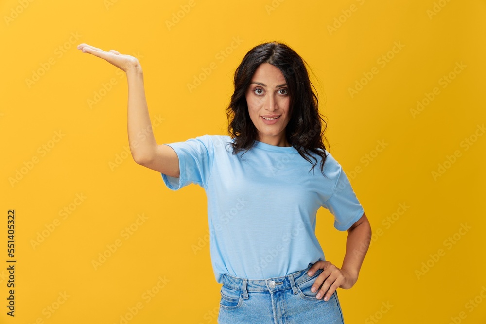 Woman signal smile with teeth emotion portrait in blue t-shirt on yellow background, hands up, surprise, lifestyle, copy space Woman signal smile with teeth emotion portrait in blue t-shirt on yellow background, hands up, surprise, lifestyle, copy space