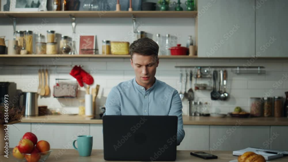 Business man opening laptop starting work at home kitchen. Freelance worker. Business man opening laptop starting work at home kitchen. Freelance worker.