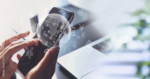 Currency exchange, money transfer, FinTech financial technology, Global business, online banking, interbank payment concept. Woman using mobile phone and laptop computer with international currency photo