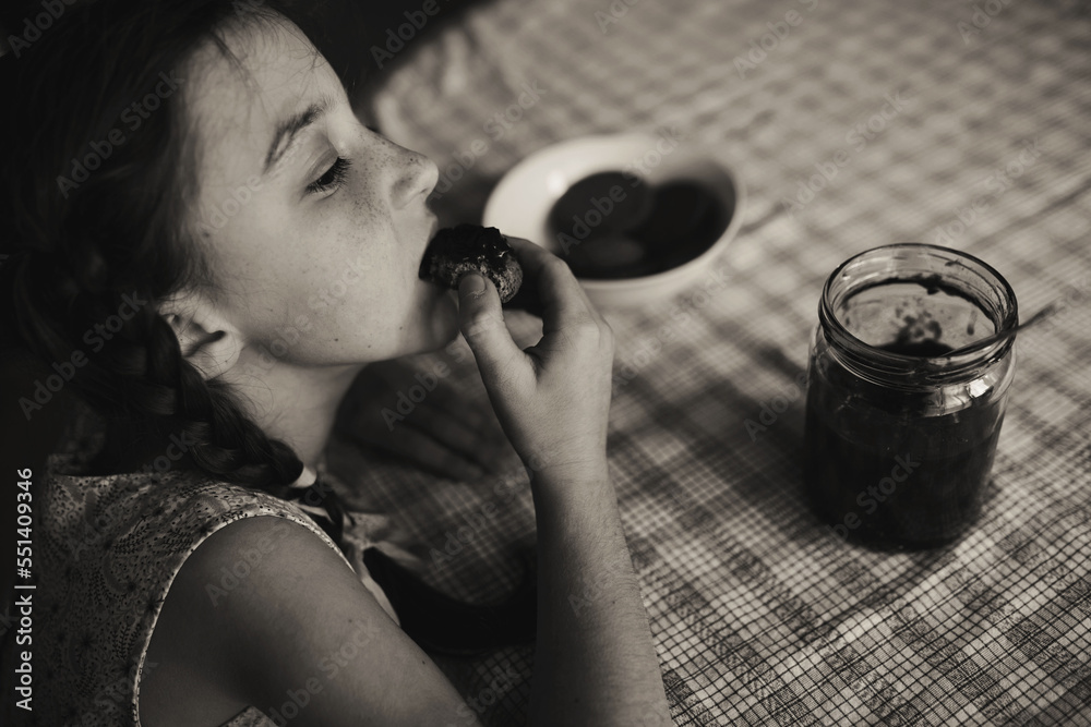 Cute funny toddler girl eats sweet bun for breakfast. Happy child ...