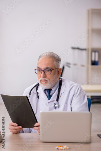 Old male doctor working in the clinic