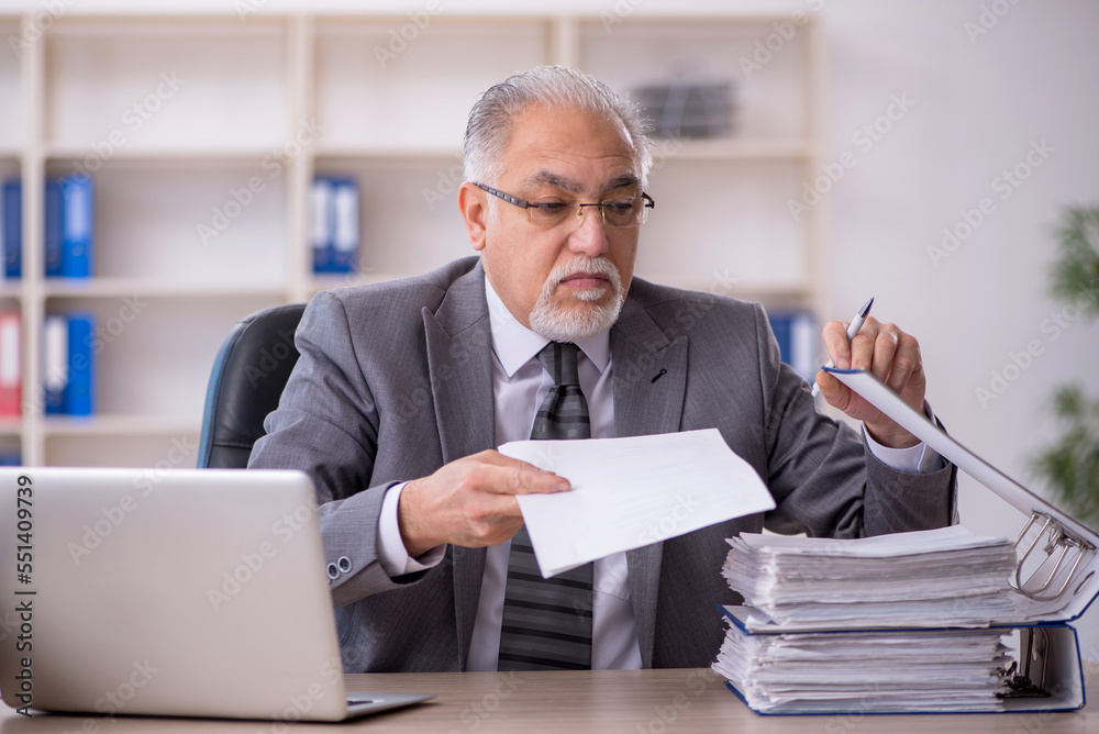 Old male employee working in the office Old male employee working in the office