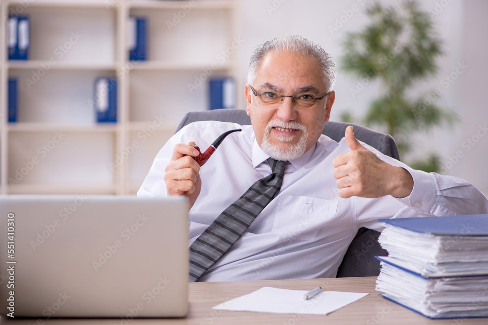 Old male employee working in the office Old male employee working in the office