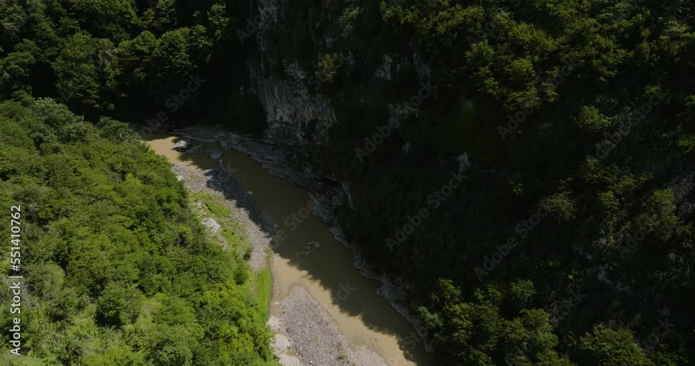 Rural area. Slow moving Aerial river by the mountain. Overgrown with trees, jungle. Rural area. Slow moving Aerial river by the mountain. Overgrown with trees, jungle.