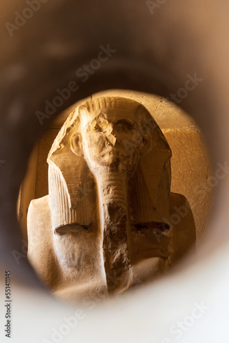 Life-sized statue of Djoser inside the Serdab ('cellar') - a limestone box near the northern entrance of the pyramid of Djoser in Saqqara, Egypt.  Travel and history.
