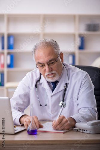 Old male doctor working in the clinic