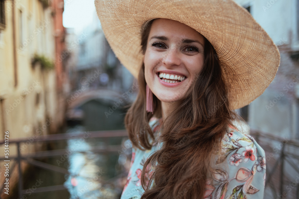 Portrait of happy woman in floral dress enjoying promenade