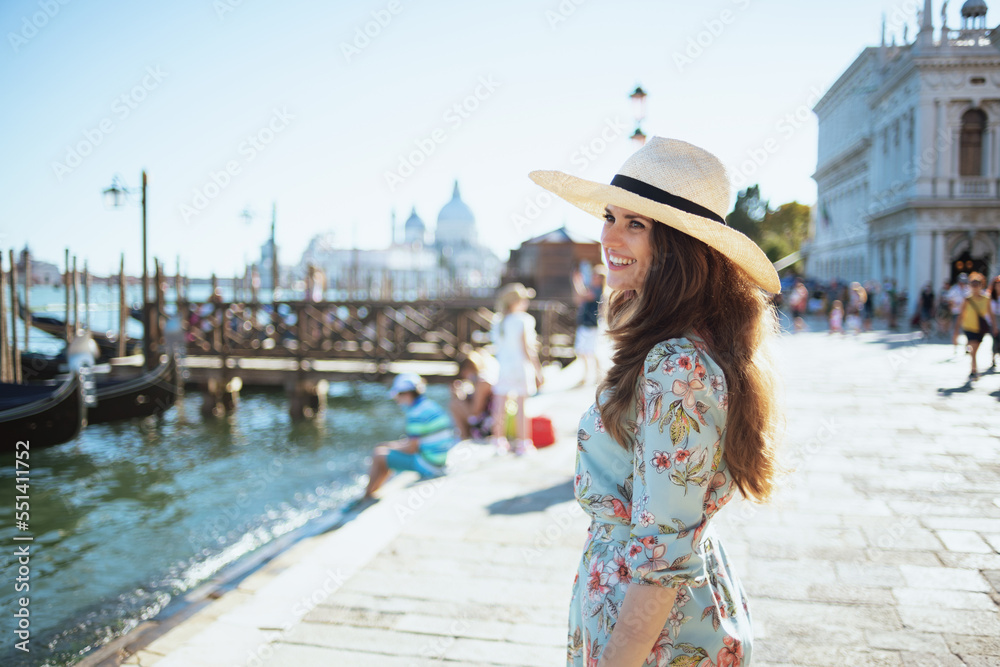smiling trendy woman in floral dress having excursion