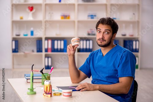 Young male dentist working in the clinic