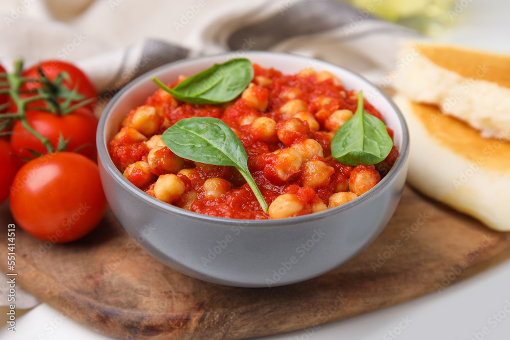 Delicious chickpea curry served on wooden board, closeup Delicious chickpea curry served on wooden board, closeup