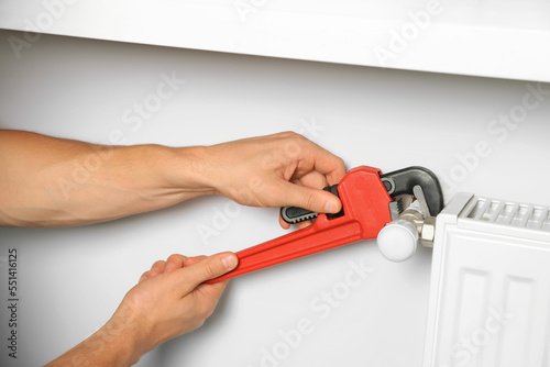 Wallpaper Mural Professional plumber using adjustable wrench for installing new heating radiator, closeup Torontodigital.ca