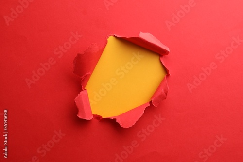 Hole in red paper on yellow background