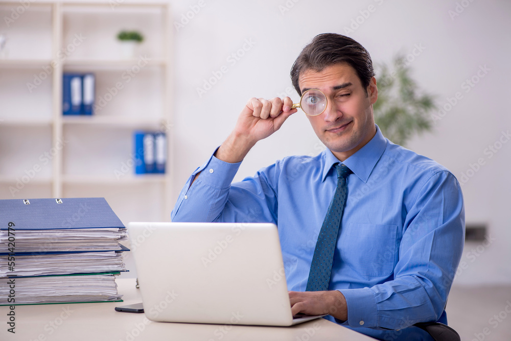 Young male employee and too much work in the office Young male employee and too much work in the office