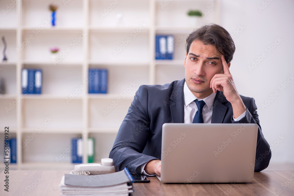 Young male employee working in the office Young male employee working in the office