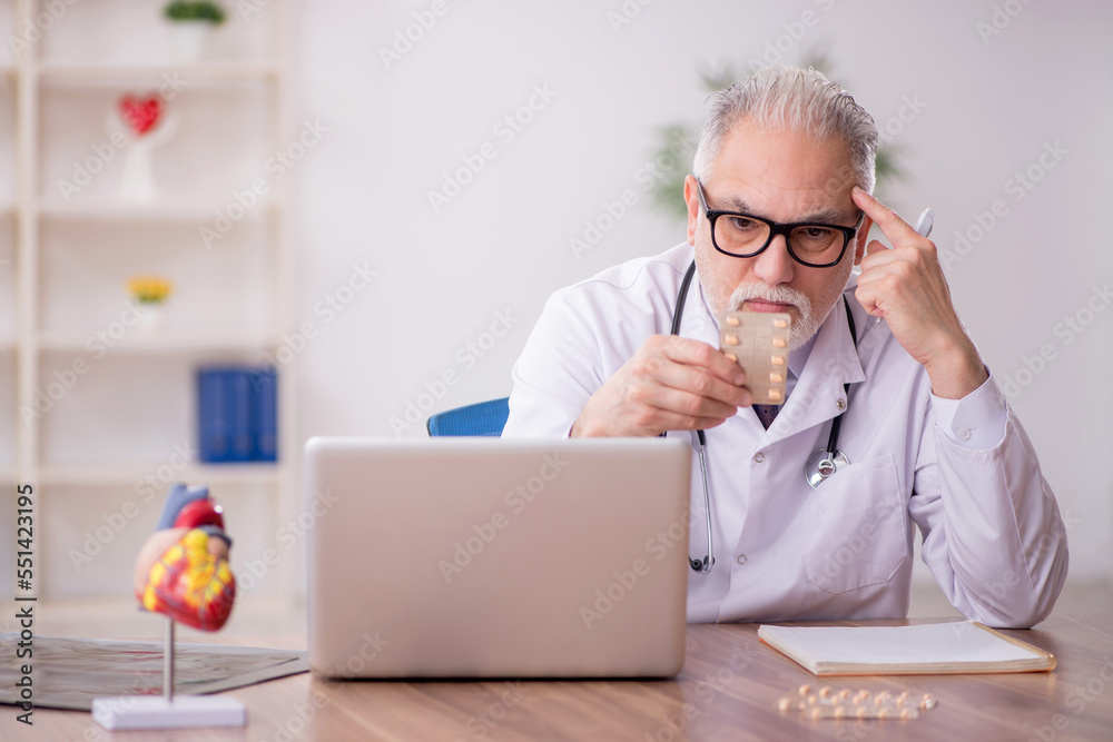 Old male doctor suggesting pills at the hospital Old male doctor suggesting pills at the hospital