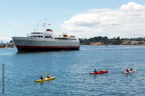 Kayakers passing a ferry near the ocean. © Alain Bechard