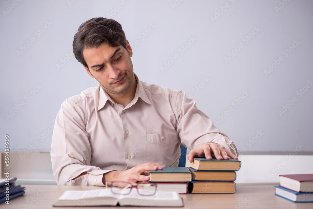 Young male teacher student sitting in the classroom Young male teacher student sitting in the classroom