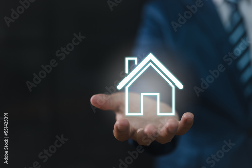 Real estate concept  a businessman holding an icon of a house. house available Property insurance and security concept Man protective gesture and house symbol