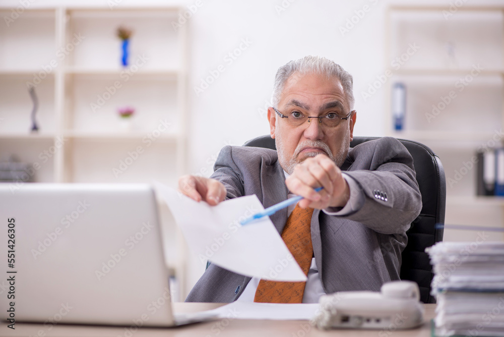 Old male employee working in the office Old male employee working in the office