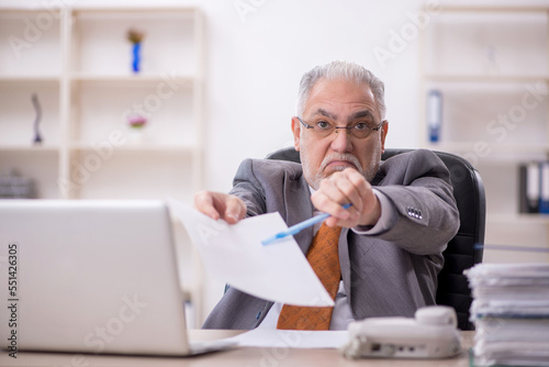 Old male employee working in the office